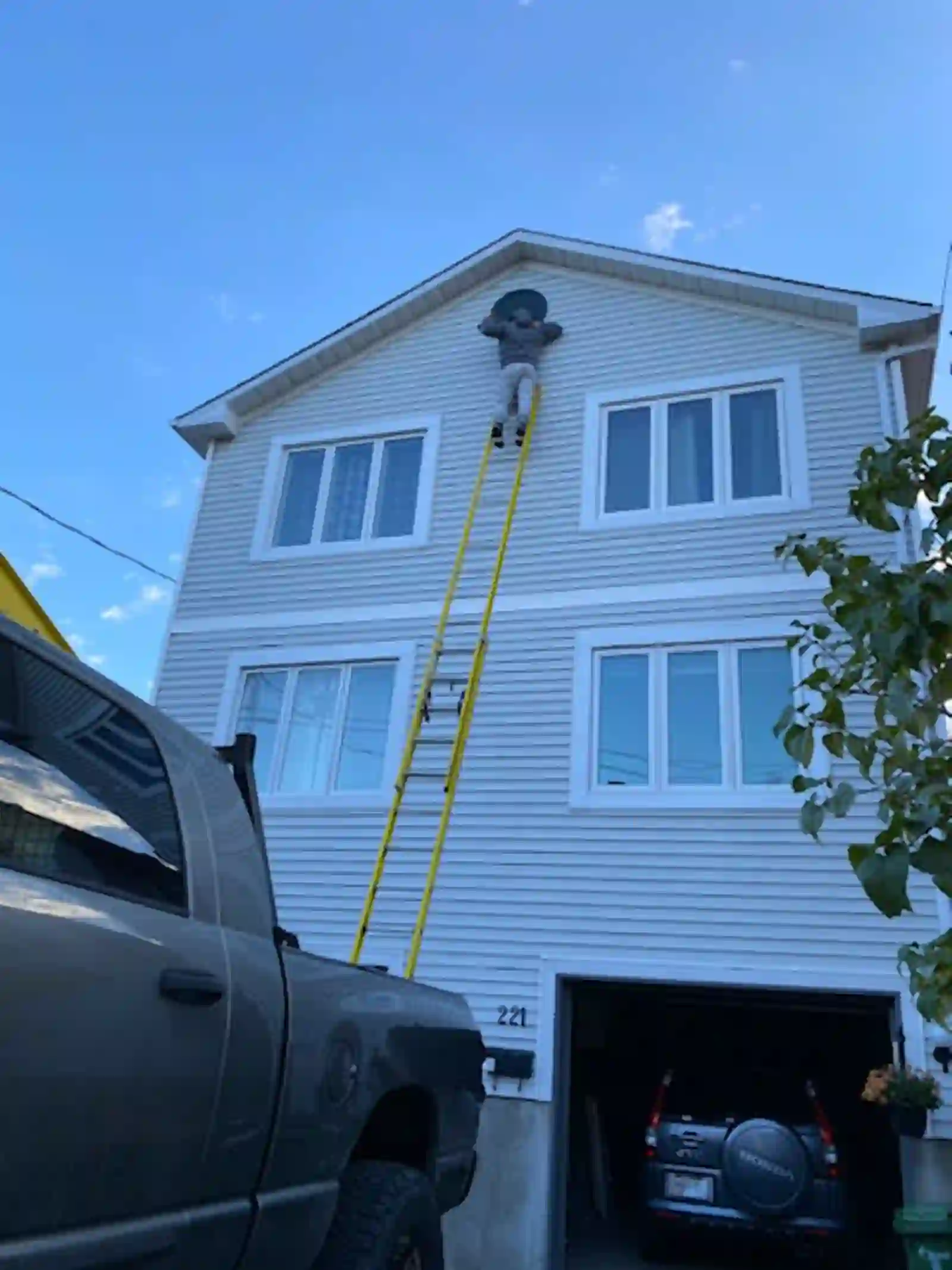 Worker on an extension ladder at a house gable