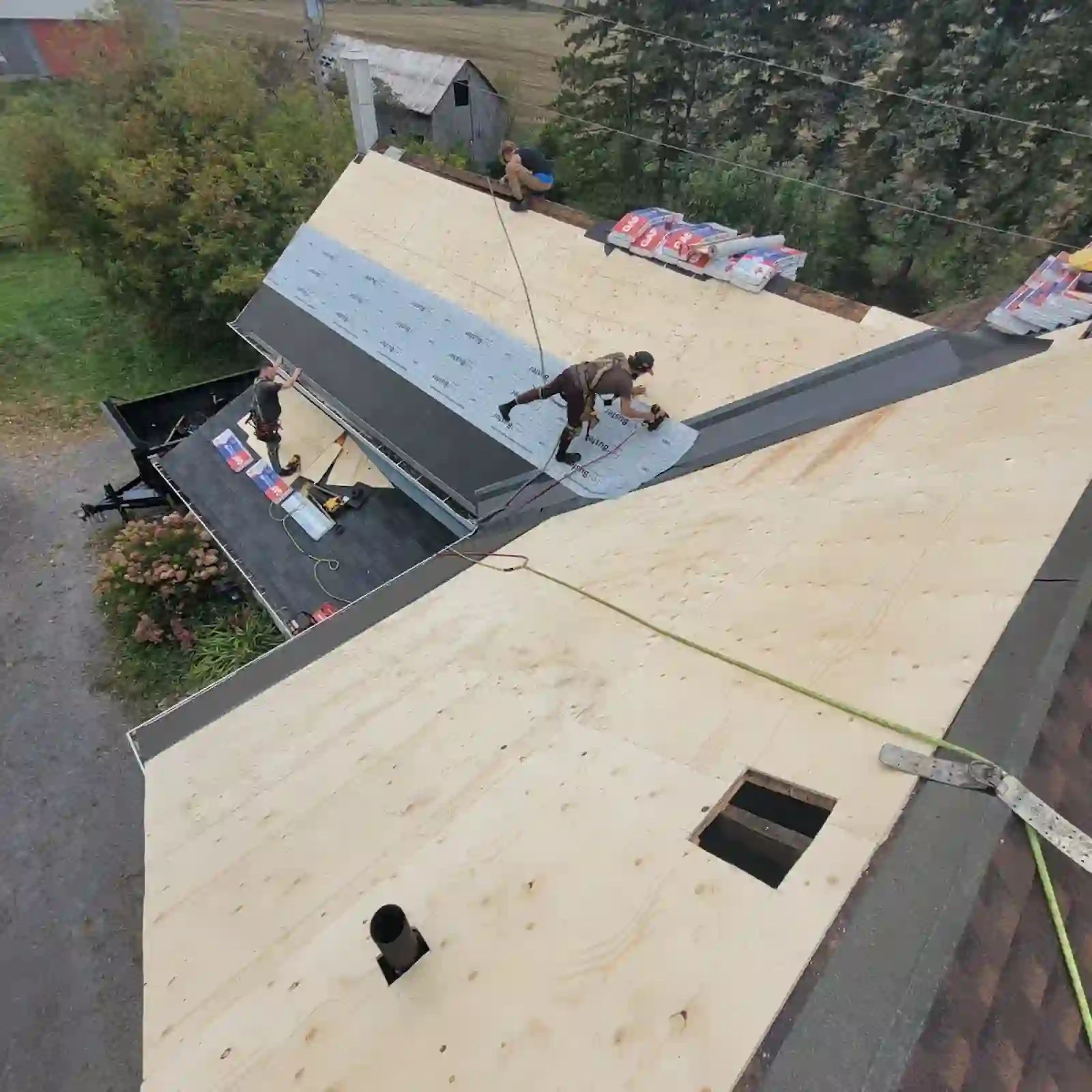 Roofers installing underlayment on a re-sheathed roof